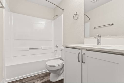 A white toilet sits in a bathroom next to a sink.