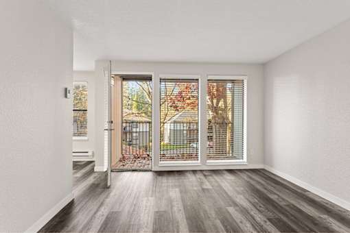 A room with a sliding door leading to a balcony.