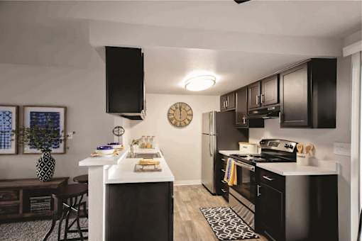 A black and white kitchen with a clock on the wall.