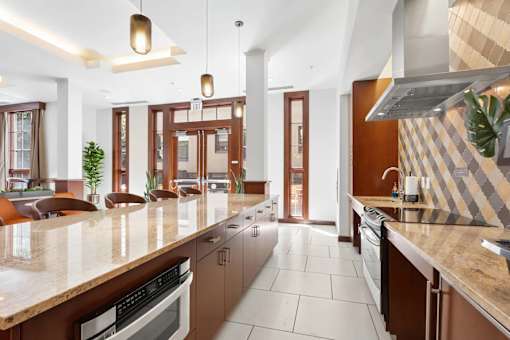 A modern kitchen with brown cabinets and a marble countertop.