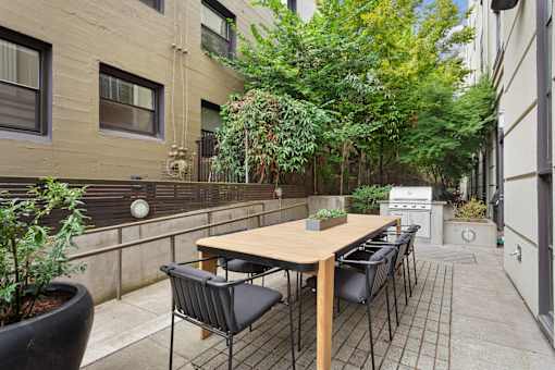 A patio with a table and chairs surrounded by buildings.