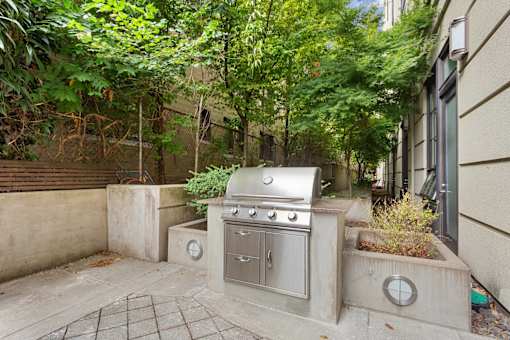 A small outdoor kitchen with a grill and sink.