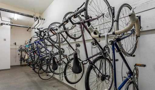 A wall of bicycles are parked in a room.
