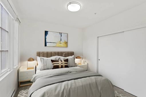 A bedroom with a large bed and a painting on the wall.
