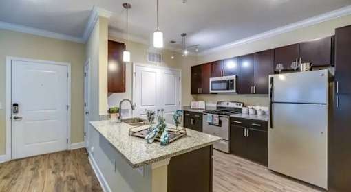 A kitchen with a granite countertop and stainless steel appliances.