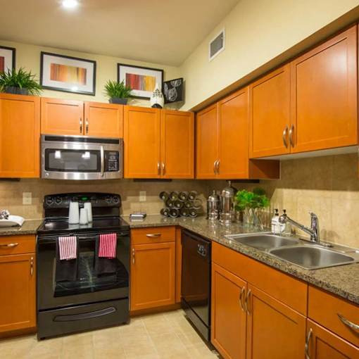 A kitchen with brown cabinets and a black oven.