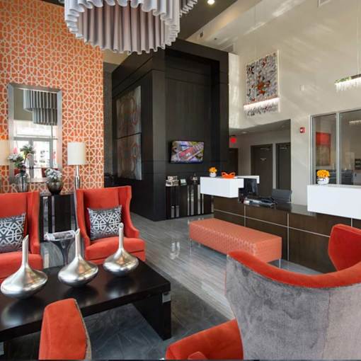 A modern living room with orange chairs and a black table.