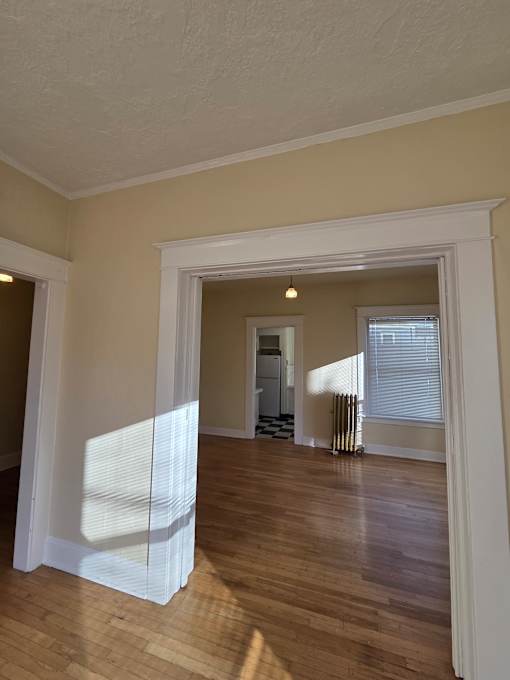 A white framed mirror is on a wooden wall. at Casa Del Rey Apartments, Portland, OR, 97209