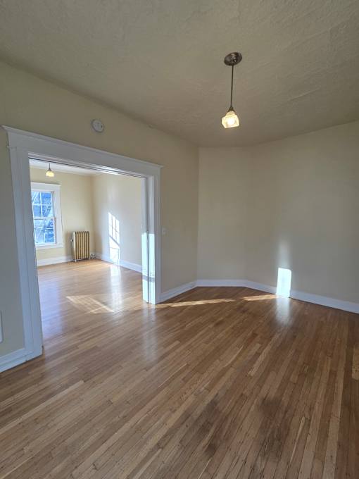 A wooden floor leads up to a window in a room with a white ceiling. at Casa Del Rey Apartments, Oregon