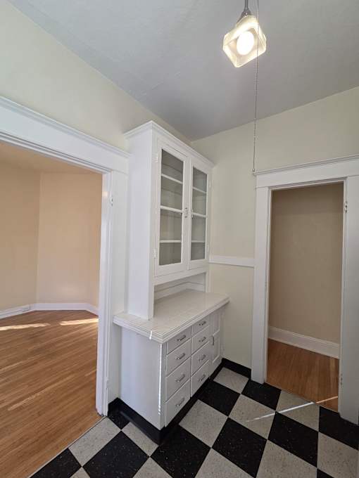 A white kitchen with a checkered floor at Casa Del Rey Apartments, Apartments, Portland, OR
