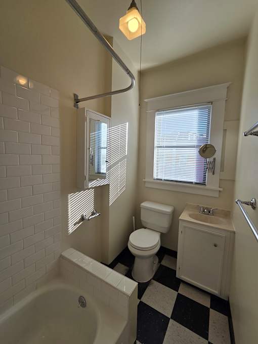 A bathroom with a white tub, sink, and toilet. at Casa Del Rey Apartments, Portland, 97209
