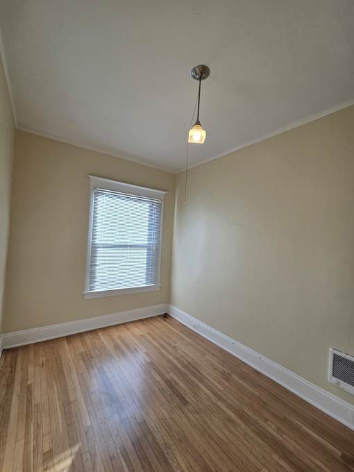 A wooden floor leads up to a window in a room with a white ceiling. at Casa Del Rey Apartments, Portland, OR, 97209