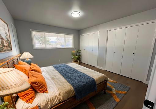 A bedroom with a bed, a window, and a lamp.