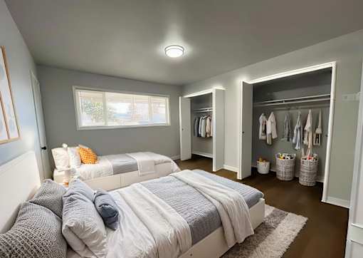A bedroom with two beds and a walk-in closet.