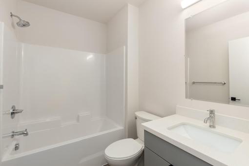 A white bathroom with a toilet, sink, and bathtub.