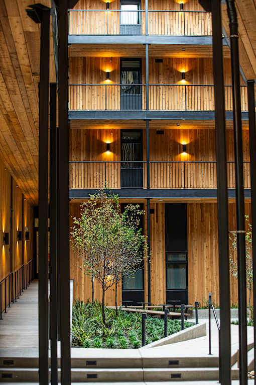 A modern building with wooden balconies and black railings at Brookland Apartments, Portland