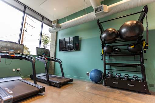A gym with treadmills, a rowing machine, and a weight rack at Brookland Apartments, Portland
