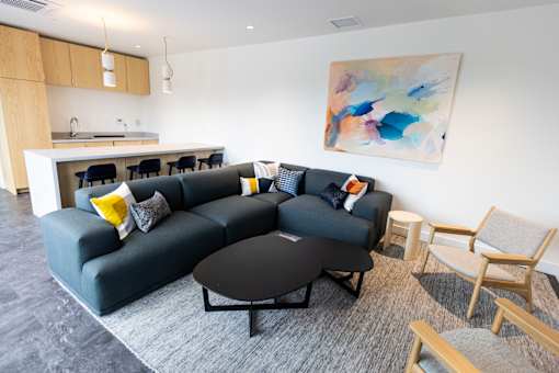 a living room with a black couch and a table and chairs at Brookland Apartments, Portland, OR