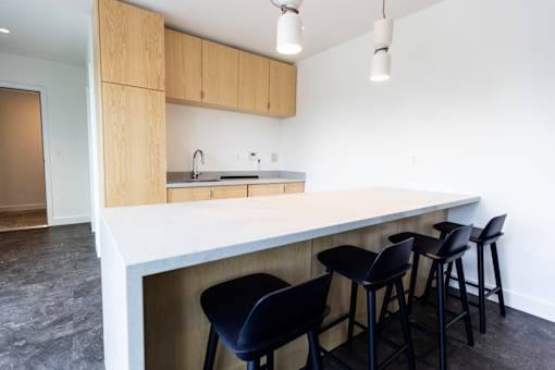 a kitchen with a white counter top and black bar stools at Brookland Apartments, Oregon
