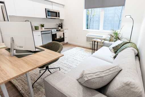 a living room with a couch and a desk with a computer at Brookland Apartments, Portland