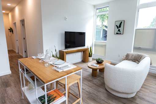 a living room with a table and a couch and a television at Brookland Apartments, Portland, OR