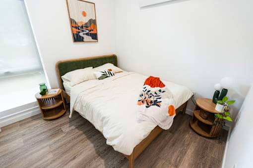 a bedroom with a bed with a white comforter and pillows at Brookland Apartments, Oregon 97202