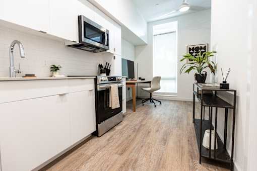 A modern kitchen with a white cabinet and a black stove top oven at Brookland Apartments, Portland