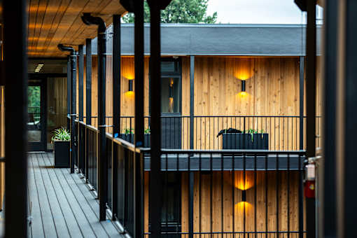 a house with wooden walls and a balcony with lights on it at Brookland Apartments, Portland, OR