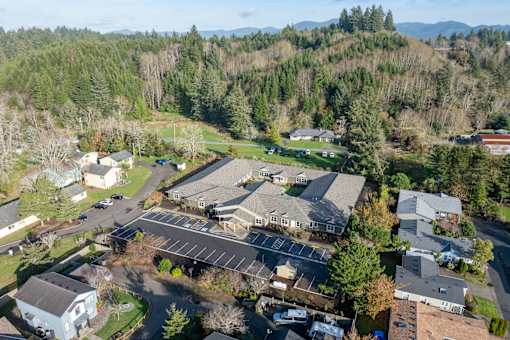A bird's eye view of a residential area with houses and a parking lot.