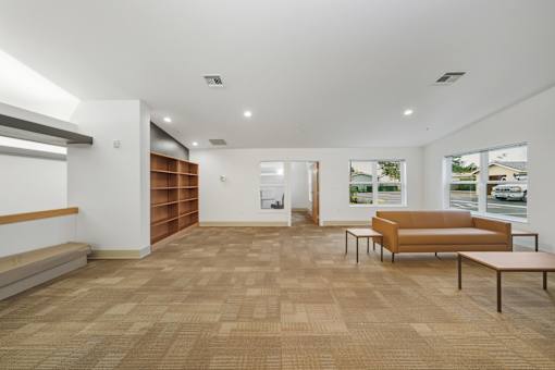 A room with a brown carpet and a brown couch.