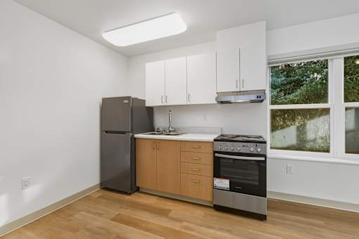 A kitchen with a black refrigerator, stove, and oven.