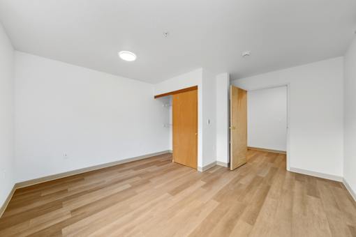 A room with a wooden floor and two doors.