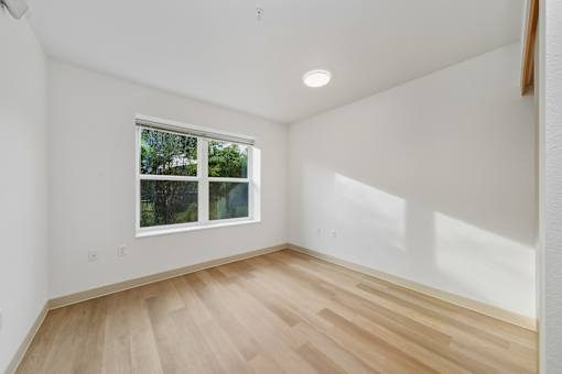 A room with a window and wooden flooring.