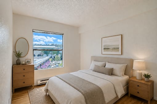 A bedroom with a large bed, a window with a view, and a wooden dresser.