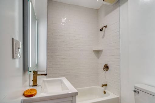 A white bathroom with a sink, mirror, and bathtub at Clay & Tiffany, Portland, 97201