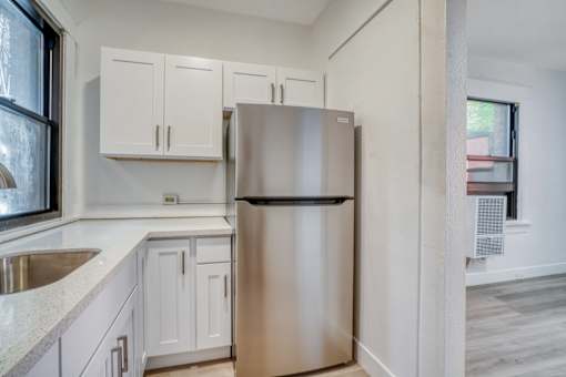 A kitchen with a stainless steel refrigerator and white cabinets at Clay & Tiffany, Portland, 97201
