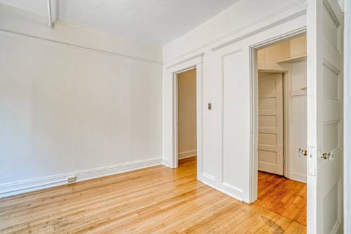 A room with white walls and wooden floors with two doors at Clay & Tiffany, Portland, 97201