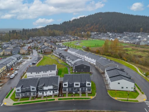 Neighborhood of houses on a street with a mountain in the background at Thrive at Green Mountain, Camas, WA, 98607