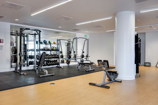 A gym with a variety of equipment including weights and cardio machines.