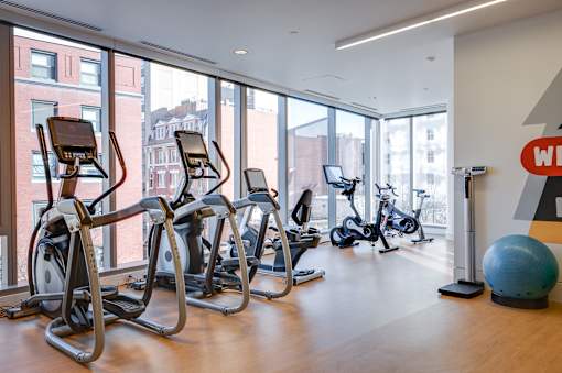 A gym with treadmills, exercise bikes and a large ball.