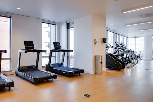 A gym with treadmills and elliptical machines.