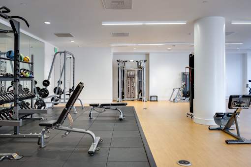 A gym with a variety of equipment including weights and cardio machines.