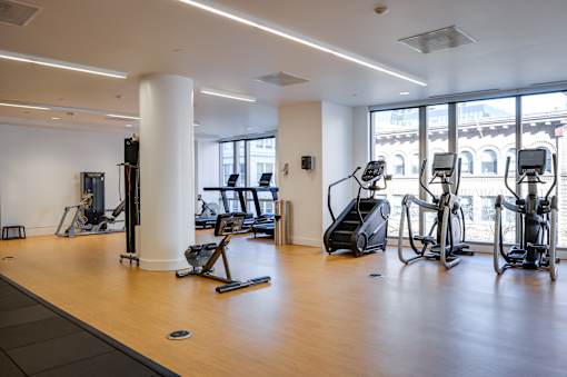 A gym with treadmills, elliptical machines, and other exercise equipment.