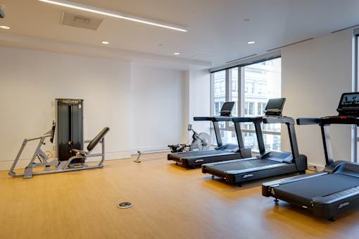 A gym with treadmills, a stationary bike, and a rowing machine.