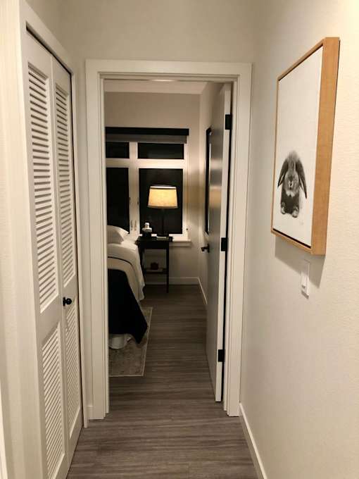 A hallway with a bedroom at the end.
