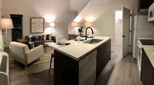 A modern kitchen with a dining area and a living room.