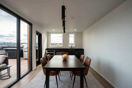 a dining room with a table and chairs and sliding glass doors at Analog Tacoma, Tacoma, WA
