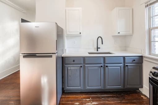 A kitchen with a stainless steel refrigerator and a grey cabinet at Midtown Apartments, Portland, OR, 97209