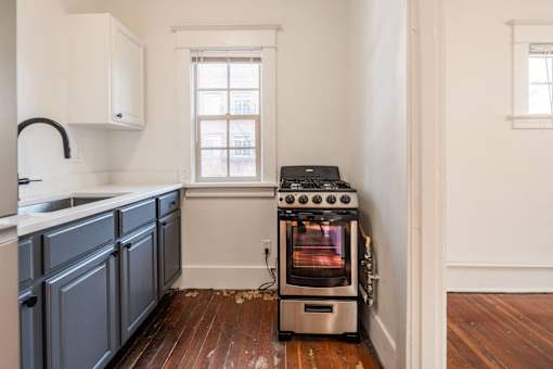 A wood stove is in a kitchen with white walls at Midtown Apartments, Portland