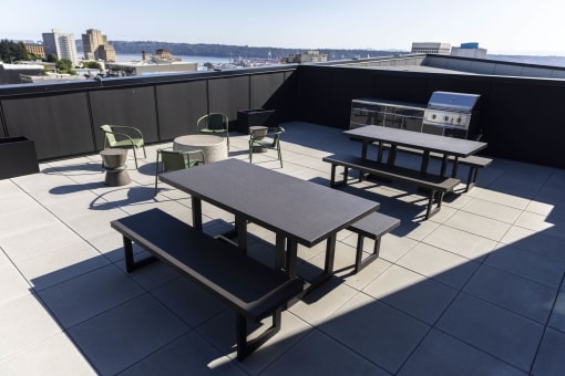 tables and chairs on the rooftop of a building with a city in the background at Moraine, Washington 98402